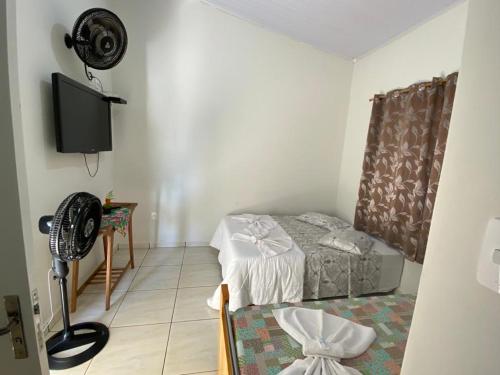 a room with a bed and a flat screen tv at Pousada Nova Estrela da Canastra in Delfinópolis