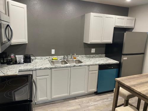 a kitchen with white cabinets and a sink at Ozark Inn & Suites in Ozark