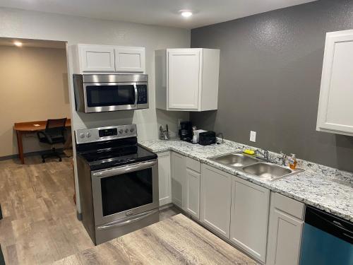 a kitchen with a sink and a stove top oven at Ozark Inn & Suites in Ozark