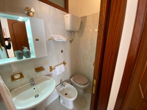 a bathroom with a sink and a toilet and a mirror at Hotel Ristorante Centosedici in Terracina