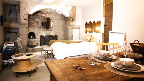 - une chambre avec un lit et une table avec des verres dans l'établissement Le Bouquiniste, centre historique, fibre, ESS, rez-de-chaussée, BedinShop, à Romans-sur-Isère