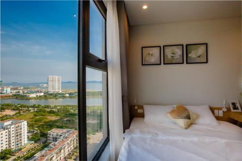 um quarto com uma cama e uma grande janela em May house Green Bay Garden Hạ Long - near Marina beach em Ha Long