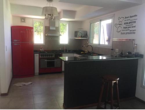 eine Küche mit einer schwarzen Theke und einem roten Kühlschrank in der Unterkunft Barrio cerrado premium in Dique Luján
