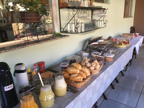 a counter with baskets of bread and other food on it at Pousada Nova Estrela da Canastra in Delfinópolis