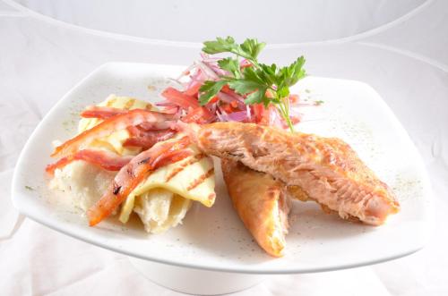 a plate of food with fish and a salad at Golden Inca Hotel in Cusco
