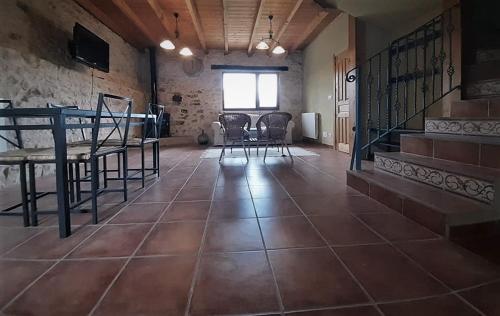 a room with a tile floor with chairs and a table at FUENTETRIGO II in Brizuela