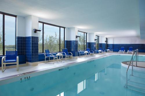 - une piscine avec des chaises bleues et du carrelage bleu dans l'établissement River Cree Resort & Casino, à Edmonton