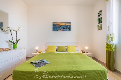 a bedroom with a large green bed with yellow pillows at Casa Acqua Dolce in Cala Gonone