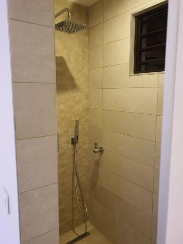 a shower with a glass door in a bathroom at Moorea Lodge in Temae