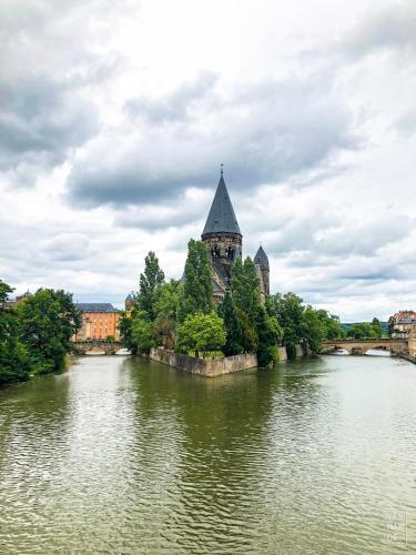 an island in the middle of a river with a church at Le Colibri - Stationnement gratuit - Balcon - Jusqu'à 4 personnes in Metz