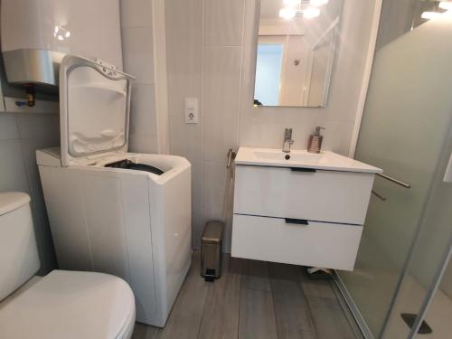 Baño blanco con aseo y lavamanos en Superbe Appartement , tout confort, 40 m2 + 10 m2 terrasse, en Empuriabrava