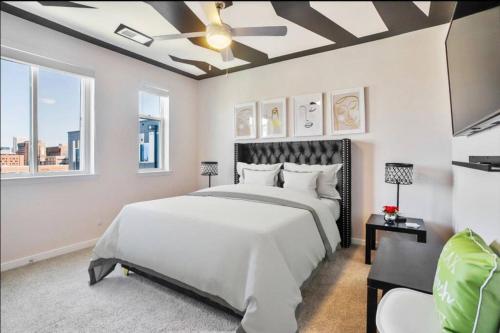 een slaapkamer met een groot bed en een plafondventilator bij Lux Penthouse Skyline, Views Gym , Free Parking & Wifi in Baltimore