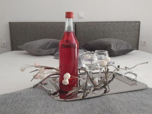a bottle of wine on a tray with glasses on a bed at Aronis Apartments in Benitses