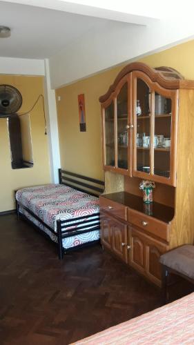 - une chambre avec un lit et une commode en bois dans l'établissement CARLOS PAZ, Dpto, 3 Huésped, à Villa Carlos Paz