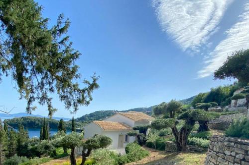 a house on a hill with trees and a lake at Paleopetres K-Nine - Premium Suite - Kalami - in Kalami