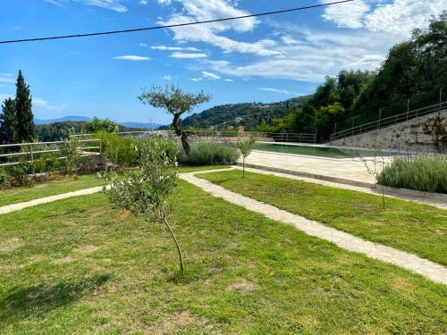 a garden with a tree on the side of a road at Paleopetres K-Nine - Premium Suite - Kalami - in Kalami