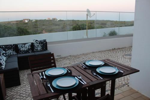 una mesa con platos azules y blancos en el balcón en Beach Front Apartment 2, en Sagres