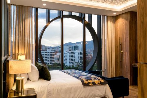 a bedroom with a bed and a large window at Hotel Marquee Medellín in Medellín