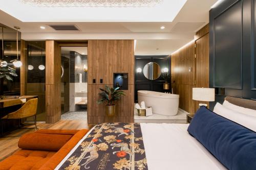 a bedroom with a bed and a bathroom with a tub at Hotel Marquee Medellín in Medellín