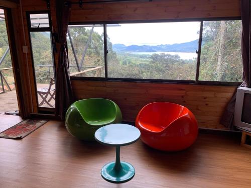two chairs and a stool in front of a window at Mirador Bosque Gran Torino Neusa in Cogua