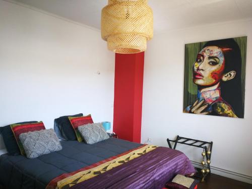 - une chambre avec un lit et une peinture d'une femme dans l'établissement Chambre d'hote Le clos Valmont, à Fécamp