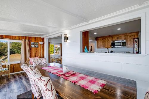 a living room with a table and a kitchen at Fisherman's Dream Boat House in Garibaldi