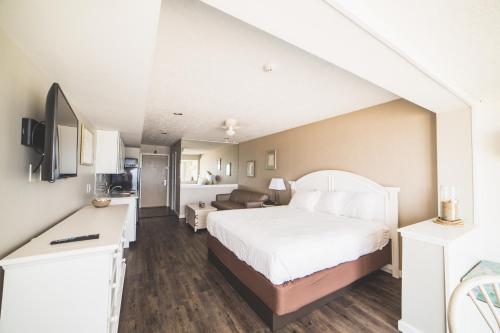 a bedroom with a bed and a living room at Surf Club Oceanfront Hotel in Dewey Beach