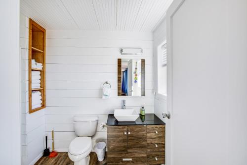 a white bathroom with a toilet and a sink at Fisherman's Dream Boat House in Garibaldi