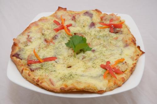 a pizza on a white plate on a table at Golden Inca Hotel in Cusco