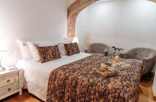 a bedroom with a large bed with a tray of food on it at Authentic Porto Apartments in Porto