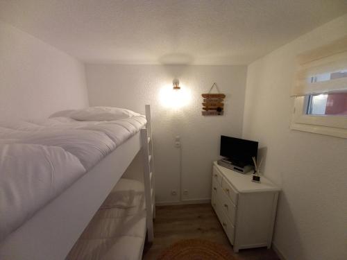 Dormitorio con cama y tocador con TV en Appartement Cabine St-Lary-Soulan, Calme, Entièrement Rénové en Saint-Lary-Soulan