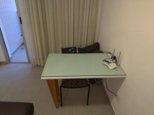 a green table in a room with a chair at Apart Hotel Quartier Latin in Vitória