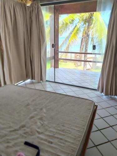 um quarto com uma cama e vista para o oceano em Casa frente mar com vista incrível! em Vera Cruz de Itaparica