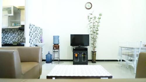 a living room with a couch and a tv at Villa Harmoni Syariah by Masterpiece Villa in Karangploso