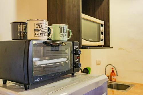 Twee koffiekopjes bovenop een broodrooster. bij Villa Stahl in San Salvador