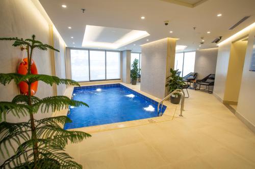 una gran piscina en una habitación con una planta en Velar Inn Hotel en Taif