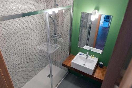 ポボア・デ・バルジンにあるApartamento Oceanus Parkの緑豊かなバスルーム(シンク、シャワー付)