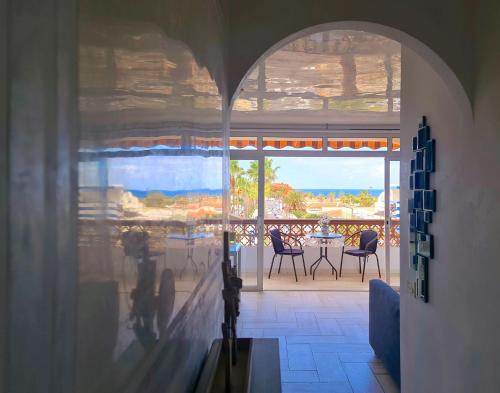 a room with a balcony with a table and chairs at Ocean View Apartment in Palm-mar