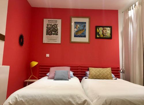- 2 lits dans une chambre aux murs rouges dans l'établissement Maison avec terrasse à Arles, Provence, à Arles