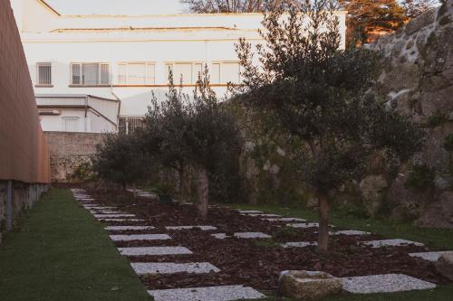 een tuin met bomen en rotsen voor een gebouw bij GuestReady - Jardim das Oliveiras GuestHouse - 2 in Porto