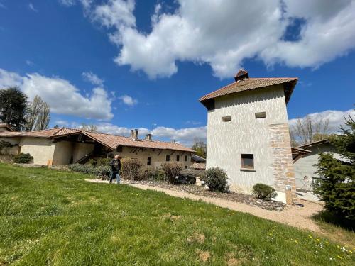 una persona parada en un campo junto a un edificio en Le Moulin de Saint-Julien, en Saint-Didier-sur-Chalaronne