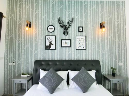 1 dormitorio con 1 cama y algunas fotos en la pared en Lux9 Private Pool Villa HuaHin en Hua Hin