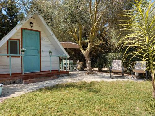 a small house with a blue door and a chair at Sunseabeach in Marzamemi