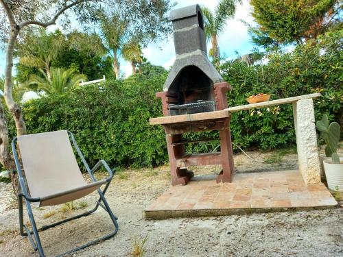 an outdoor oven with a chair next to it at Sunseabeach in Marzamemi