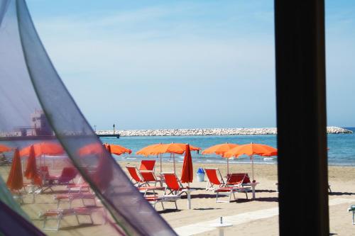 a group of chairs and umbrellas on a beach at Park Hotel Villa Americana in Rodi Garganico