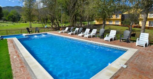 uma piscina com espreguiçadeiras e uma piscina em Posada Quellen em Villa General Belgrano