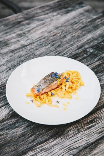 a plate of pasta with a piece of fish on it at s'Hoamatl Dorfkrug Appartements in Seefeld in Tirol