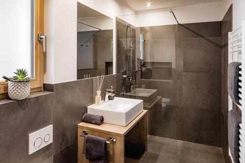 a bathroom with a sink and a mirror at Sweet Dolomiti Sonneck in Maranza