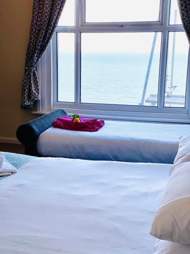 a bedroom with two beds and a large window at Villa Mentone Hotel in Shanklin