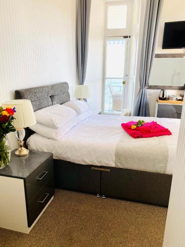 a bedroom with a large bed and a window at Villa Mentone Hotel in Shanklin